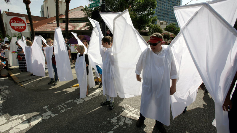 Counter demonstrators dressed as angels to show support and solidarity block the view of protesters near the funeral service for Christopher Andrew Leinonen, one of the victims of the Pulse nightclub mass shooting, outside the Cathedral Church of St. Luke on Saturday in Orlando, Fla. / John Raoux/AP